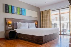 a bedroom with a large bed and a large window at Holiday Inn Resort Phuket Karon Beach, an IHG Hotel in Karon Beach