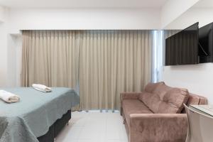 una sala de estar con un sofá y una cama en Makia114experience, en Porto de Galinhas
