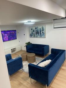 una sala de estar con sofás azules en una habitación en Stylish 2 Bedroom suite in SW Edmonton close to Windermere and Edmonton International Airport en Edmonton