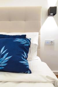 a bed with a blue and white pillow on it at A1.0 - Alexa Smart house in Braga