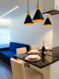 a dining room with a table and a blue couch at A1.0 - Alexa Smart house in Braga