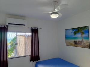 una camera da letto con ventilatore a soffitto e finestra di Apartamento 202 Peterle Irirí a Anchieta