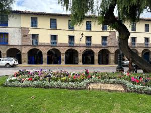 un lecho de flores frente a un edificio en Posada Villa Mayor en Cuzco