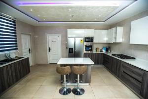 a kitchen with a table and a refrigerator at Elegant and Cosy Four Bedroom Home in Accra in Accra