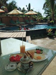 a tray of food on a table next to a pool at Jiva Bungalow in Nusa Lembongan