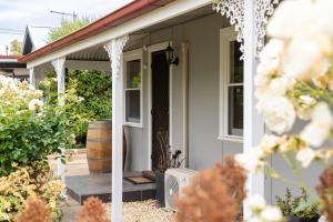 a front porch of a white house with flowers at Ruby's Cottage in Penola