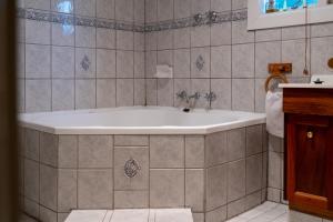 a bathroom with a bath tub in a tiled room at Ruby's Cottage in Penola