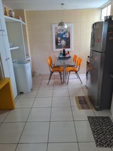 eine Küche mit einem Tisch und Stühlen sowie einem Kühlschrank in der Unterkunft APARTAMENTO ENCANTADOR NA ZONA LESTE in Teresina