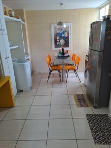 una cucina con tavolo, sedie e frigorifero di APARTAMENTO ENCANTADOR NA ZONA LESTE a Teresina