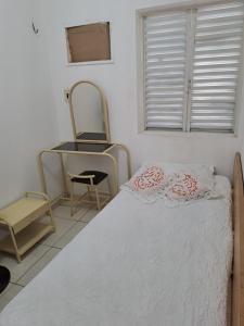 a bedroom with a bed and a desk and a mirror at APARTAMENTO ENCANTADOR NA ZONA LESTE in Teresina
