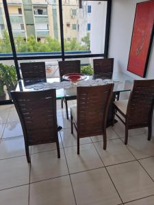 una sala da pranzo con tavolo, sedie e una finestra di APARTAMENTO ENCANTADOR NA ZONA LESTE a Teresina Altre 20 foto