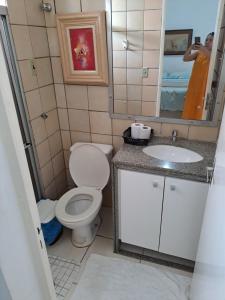 a bathroom with a toilet and a sink and a mirror at APARTAMENTO ENCANTADOR NA ZONA LESTE in Teresina