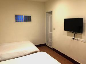 a room with two beds and a flat screen tv at 尋 清芳民宿 瑞芳車站-九份 平溪 in Ruifang