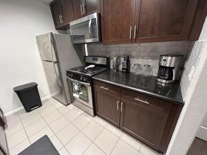 a kitchen with wooden cabinets and a stainless steel refrigerator at 2 Bedroom Apartment Downtown LA! in Los Angeles