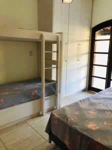 - une chambre avec 2 lits superposés et une fenêtre dans l'établissement Sítio Encantador na Cidade de Jarinu, à Jarinu