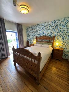 a bedroom with a wooden bed with blue wallpaper at Posada Villa Mayor in Cusco