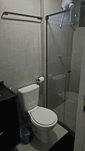 uma casa de banho com um WC e uma cabina de duche em vidro. em Seja um hóspede de charme num flat-boutique a 80m do mar de Porto em Porto de Galinhas
