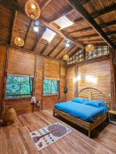 a bedroom with a bed in a wooden cabin at Yogachal Vista Mar Bamboo House in the Jungle in Ojochal