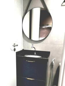 uma casa de banho com um lavatório preto e um espelho em Seja um hóspede de charme num flat-boutique a 80m do mar de Porto em Porto de Galinhas
