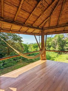 Habitación grande con suelo de madera y techo de madera. en Yogachal Vista Mar Bamboo House in the Jungle, en Ojochal