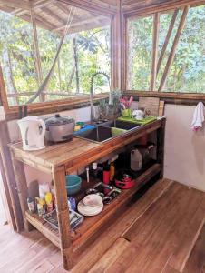 cocina con fregadero y barra con platos en Yogachal Vista Mar Bamboo House in the Jungle, en Ojochal