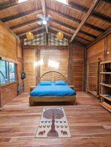 a bedroom with a bed in a wooden room at Yogachal Vista Mar Bamboo House in the Jungle in Ojochal