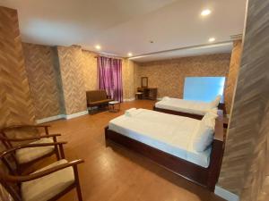 ein Schlafzimmer mit 2 Betten und einem Stuhl darin in der Unterkunft FriendZoneS Hotel in Ấp Bình Hưng