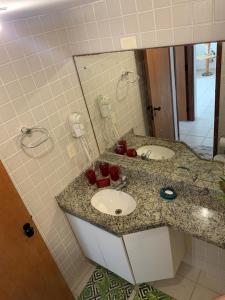 a bathroom with a sink and a mirror at Muro Alto Marupiara Suítes in Porto De Galinhas