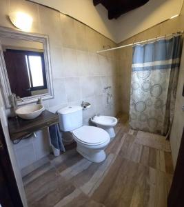 a bathroom with two toilets and a sink and a shower at Departamento con piscina en Vistalba in Vistalba