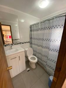 a bathroom with a toilet and a shower curtain at Casa Josefa in Pelluhue