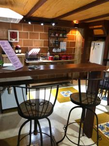 a kitchen with a counter with two chairs and a table at Casa de Praia - meu lugar em Iriri in Anchieta +22 photos