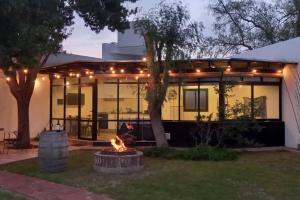 a house with a fire pit in front of it at Departamento con piscina en Vistalba in Vistalba