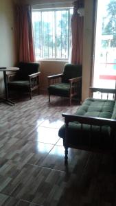 a waiting room with couches and chairs and windows at Cabañas Familiares Puente de Tralca 6 in El Quisco