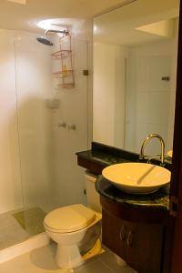 a bathroom with a toilet and a sink and a shower at Apartamento al oeste de Cali in Cali