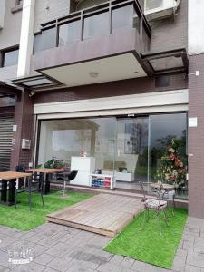 - un bâtiment avec une terrasse dotée d'une table et de chaises dans l'établissement 宜蘭頭城空空如也Kong Kong, à Toucheng