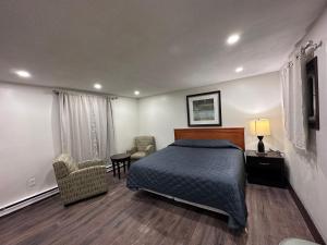 1 dormitorio con 1 cama, 2 sillas y mesa en Cedar Springs Motel, en Acton