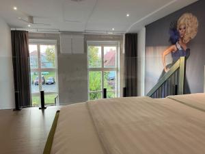 ein Zimmer mit einem Bett und einem Gemälde einer Frau an der Wand in der Unterkunft Duplex Loft mit Garten in Magdeburg