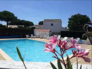 eine Villa mit einem Pool und einer Blume in der Unterkunft Maison Bretignolles-sur-Mer, 1 pièce, 5 personnes - FR-1-231-295 in Brétignolles-sur-Mer