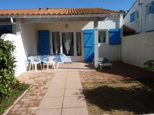 eine Terrasse mit einem Tisch und Stühlen in einem Haus in der Unterkunft Maison Bretignolles-sur-Mer, 1 pièce, 5 personnes - FR-1-231-295 in Brétignolles-sur-Mer