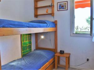 Ce dortoir comprend 2 lits superposés et une fenêtre. dans l'établissement Appartement Bormes-les-Mimosas, 2 pièces, 4 personnes - FR-1-251-571, à Bormes-les-Mimosas