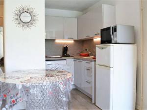 La cuisine est équipée de placards blancs et d'un réfrigérateur blanc. dans l'établissement Appartement Bormes-les-Mimosas, 2 pièces, 4 personnes - FR-1-251-571, à Bormes-les-Mimosas