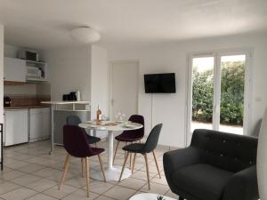 ein Wohnzimmer mit einem Tisch und Stühlen sowie eine Küche in der Unterkunft Appartement Bretignolles-sur-Mer, 3 pièces, 5 personnes - FR-1-231-296 in Brétignolles-sur-Mer