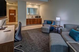 uma sala de estar com um sofá e cadeiras num quarto em Courtyard by Marriott Dulles Airport Herndon em Herndon