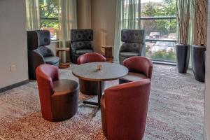 a room with chairs and a table and a table and chairs at Courtyard by Marriott Dulles Airport Herndon in Herndon