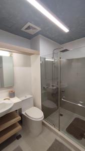 een badkamer met een toilet, een douche en een wastafel bij Tu Casa at Pico de Loro in Nasugbu