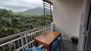 een balkon met een houten tafel en blauwe stoelen bij Tu Casa at Pico de Loro in Nasugbu