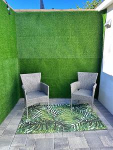 two chairs sitting in front of a green wall at Gorgeous house in Los Angeles in Los Angeles