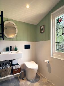 a bathroom with a white toilet and a sink at Bundanoon Garden Retreat in Bundanoon