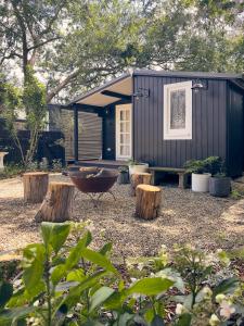 a small black shed with a yard with trees at Bundanoon Garden Retreat in Bundanoon