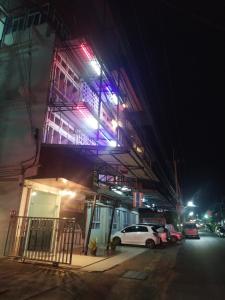 un edificio con un coche aparcado fuera por la noche en โรงแรมพรถวิล ศรีสะเกษ Sisaket PonTaWin Budget Inn, en Sisaket